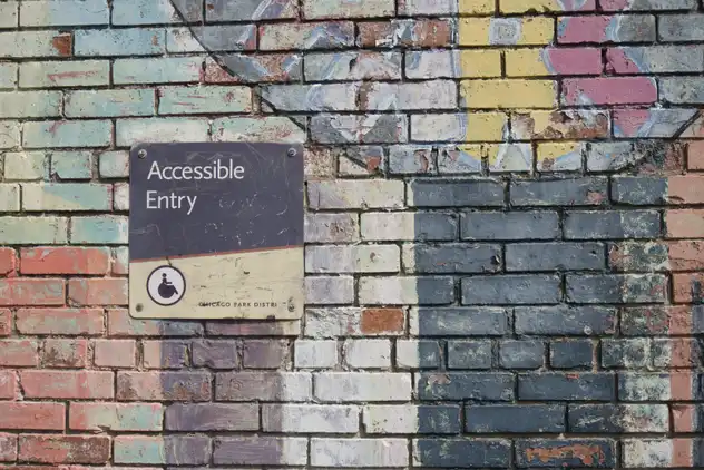 Accessible access sign on brick wall